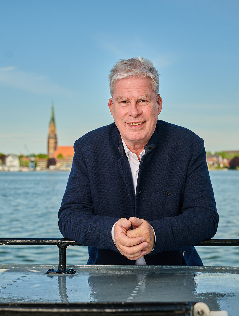 wolfgang schoofs steht angelehnt an ein boot vor der schlei