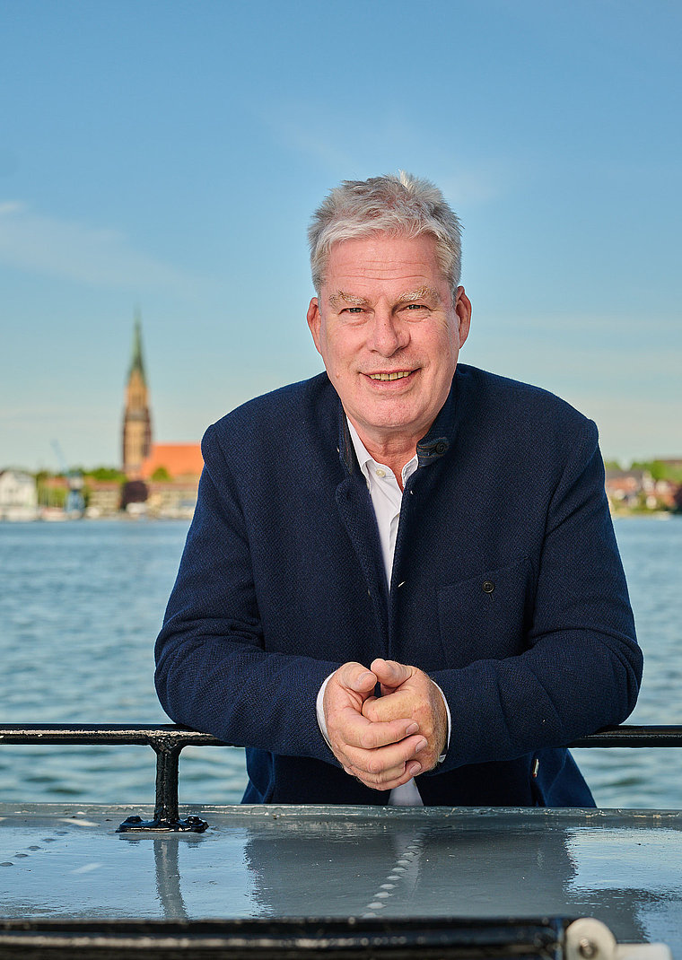 wolfgang schoofs steht angelehnt an ein boot vor der schlei